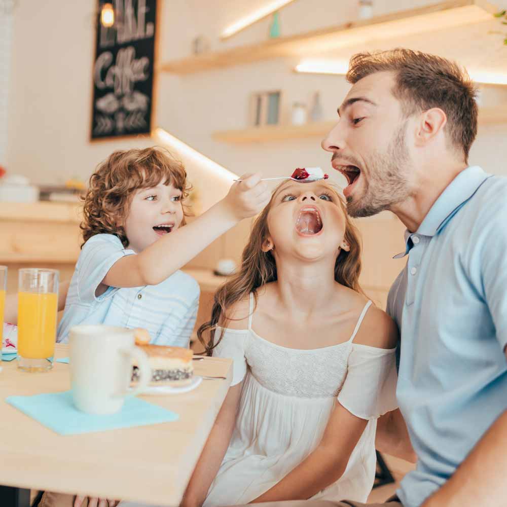beautiful-young-family-eating-sweets-in-cafe-with-2023-11-27-05-30-34-utc